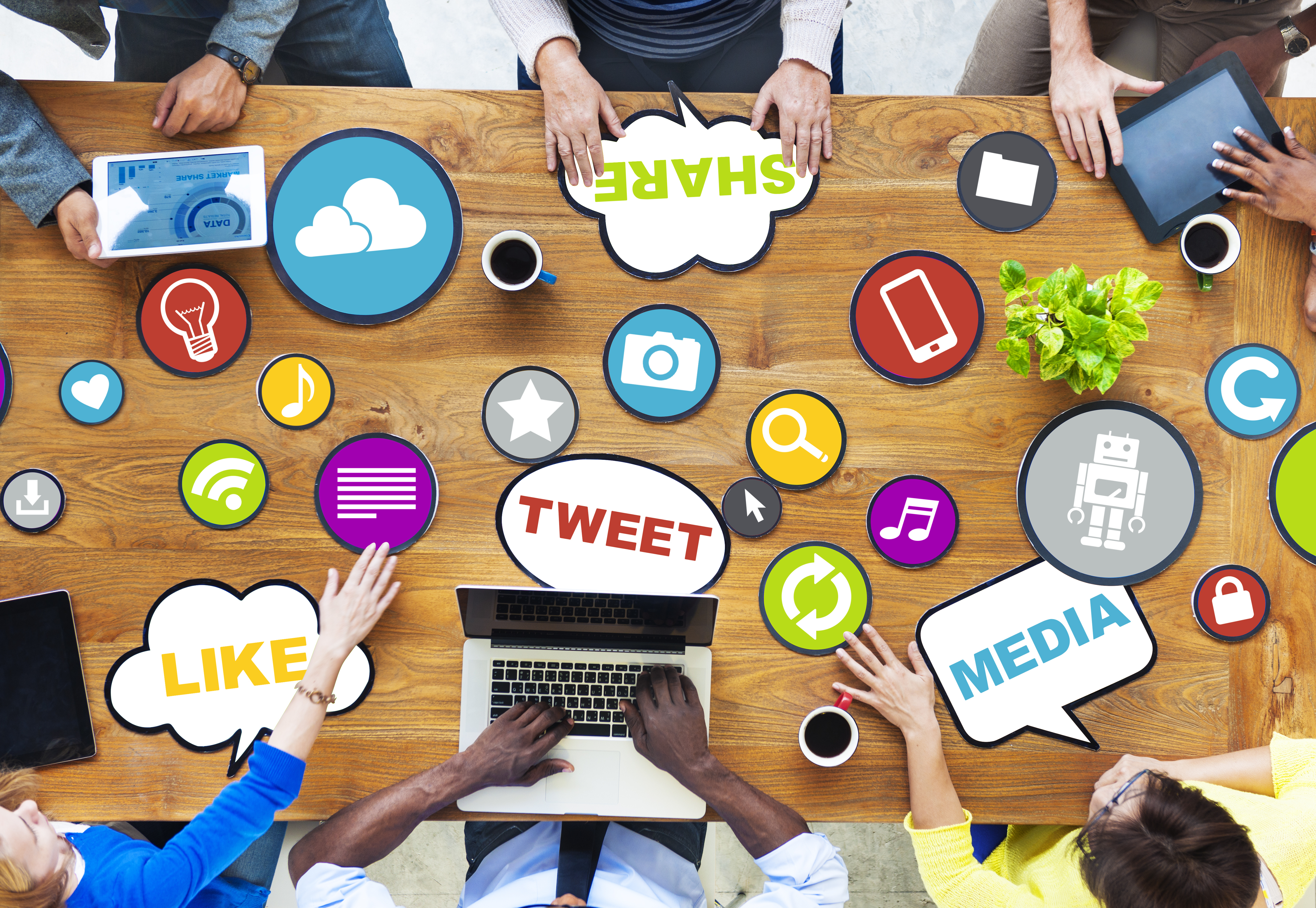 Image: people at a table with social media logos on the table